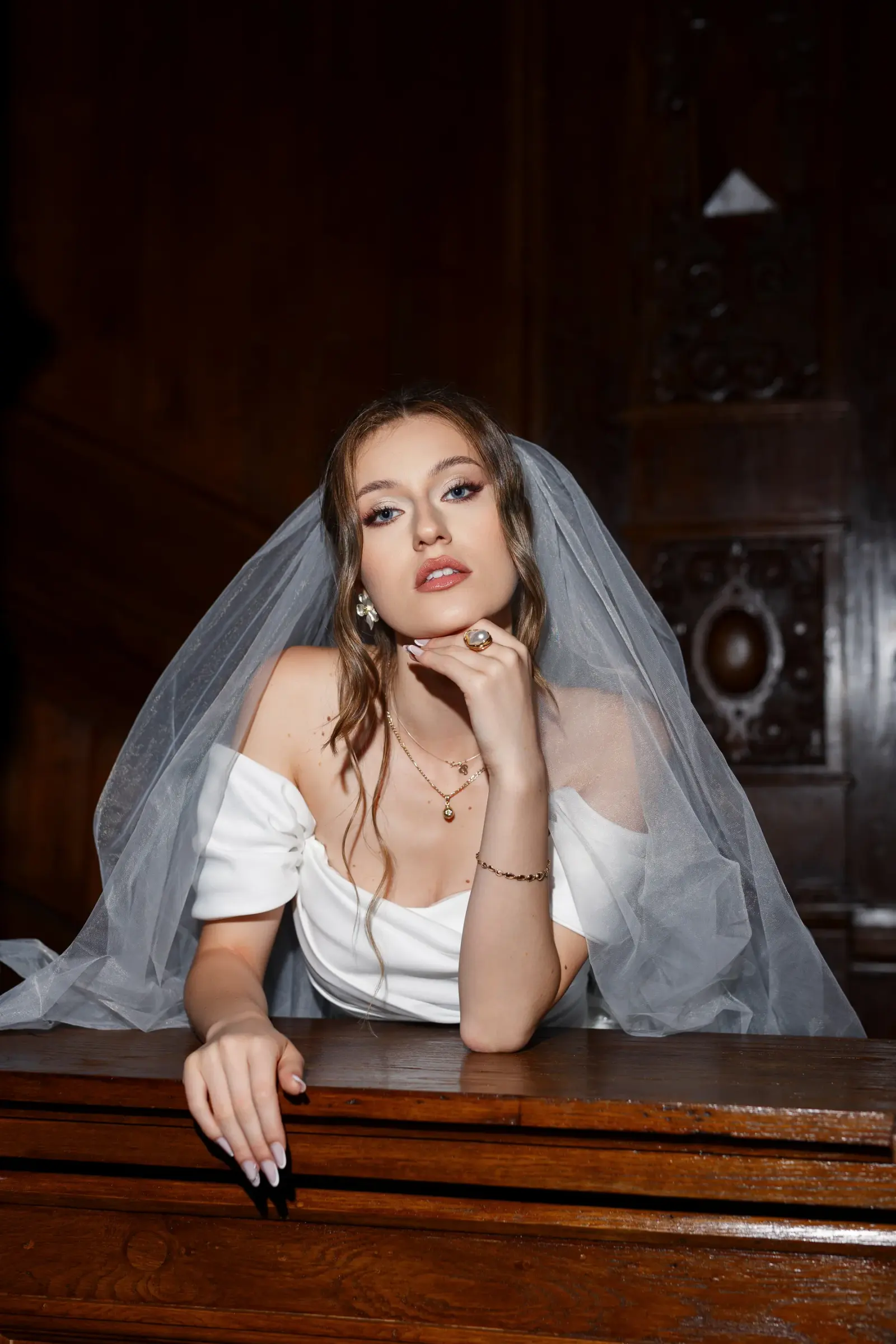 Portret al unei modele brunete purtând voal și rochie de mireasă